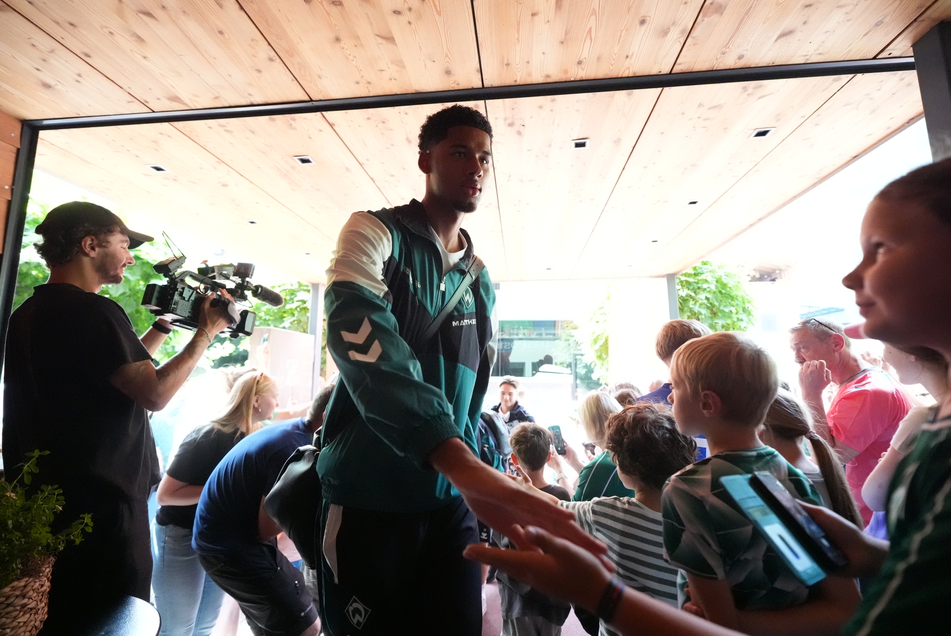 Salim Musah klatscht Fans bei der Ankunft im Trainingslager ab.