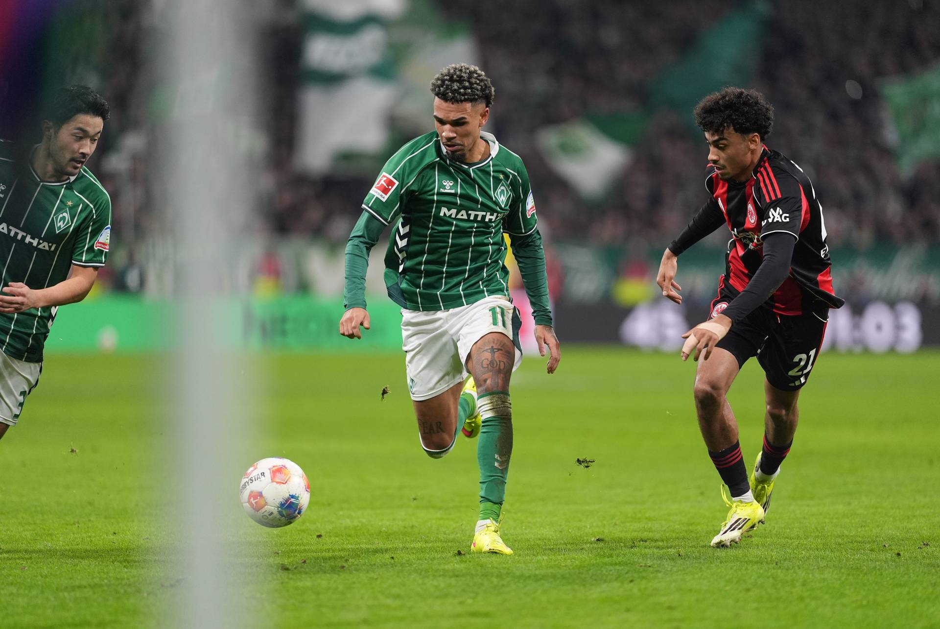 Justin Njinmah chases the ball, as does Frankfurt's Nathaniel Brown.