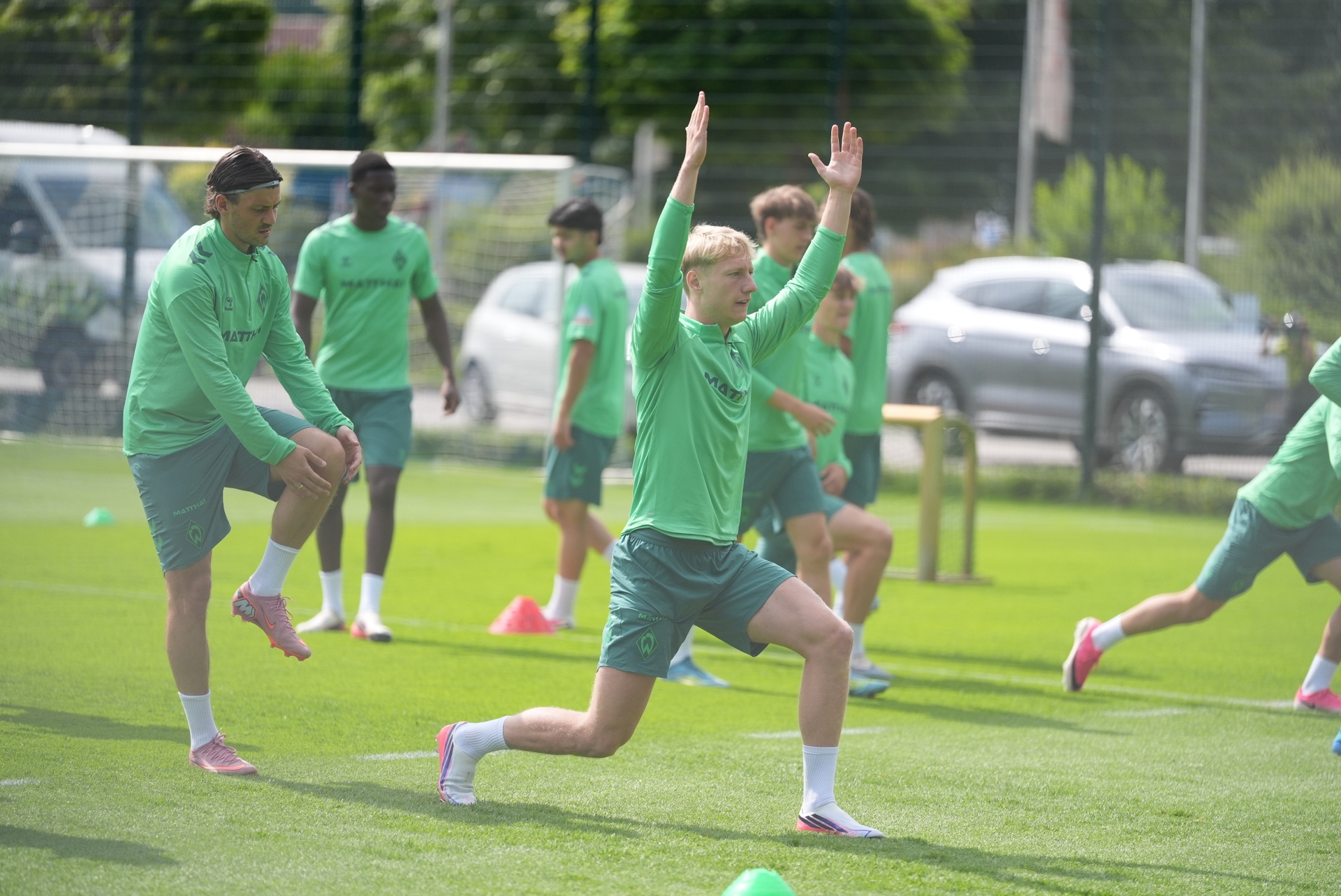 Oskar Wójcik macht eine Dehnübung auf dem Trainingsplatz.