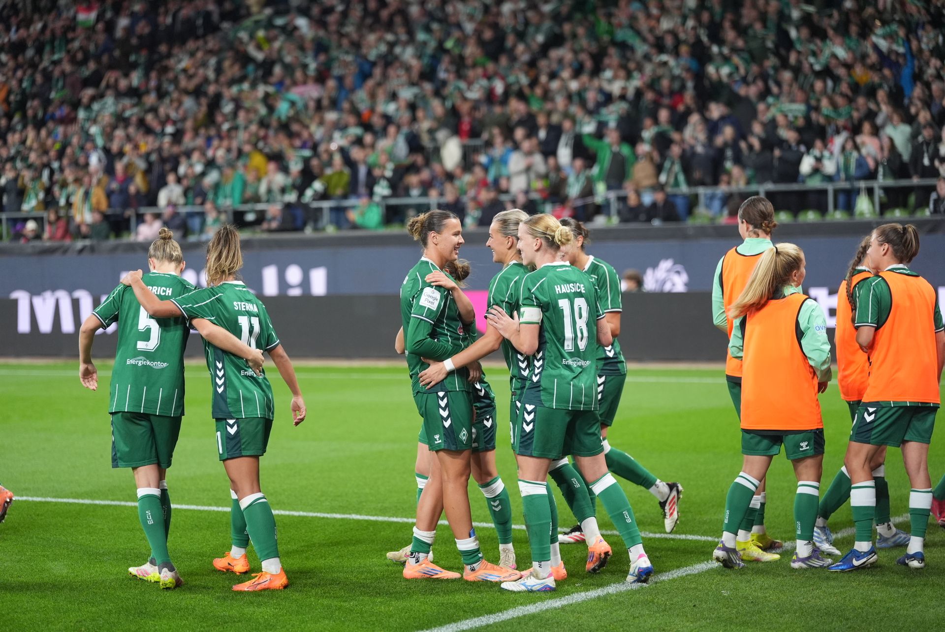 Die Spielerinnen jubeln vor der Ostkurve.