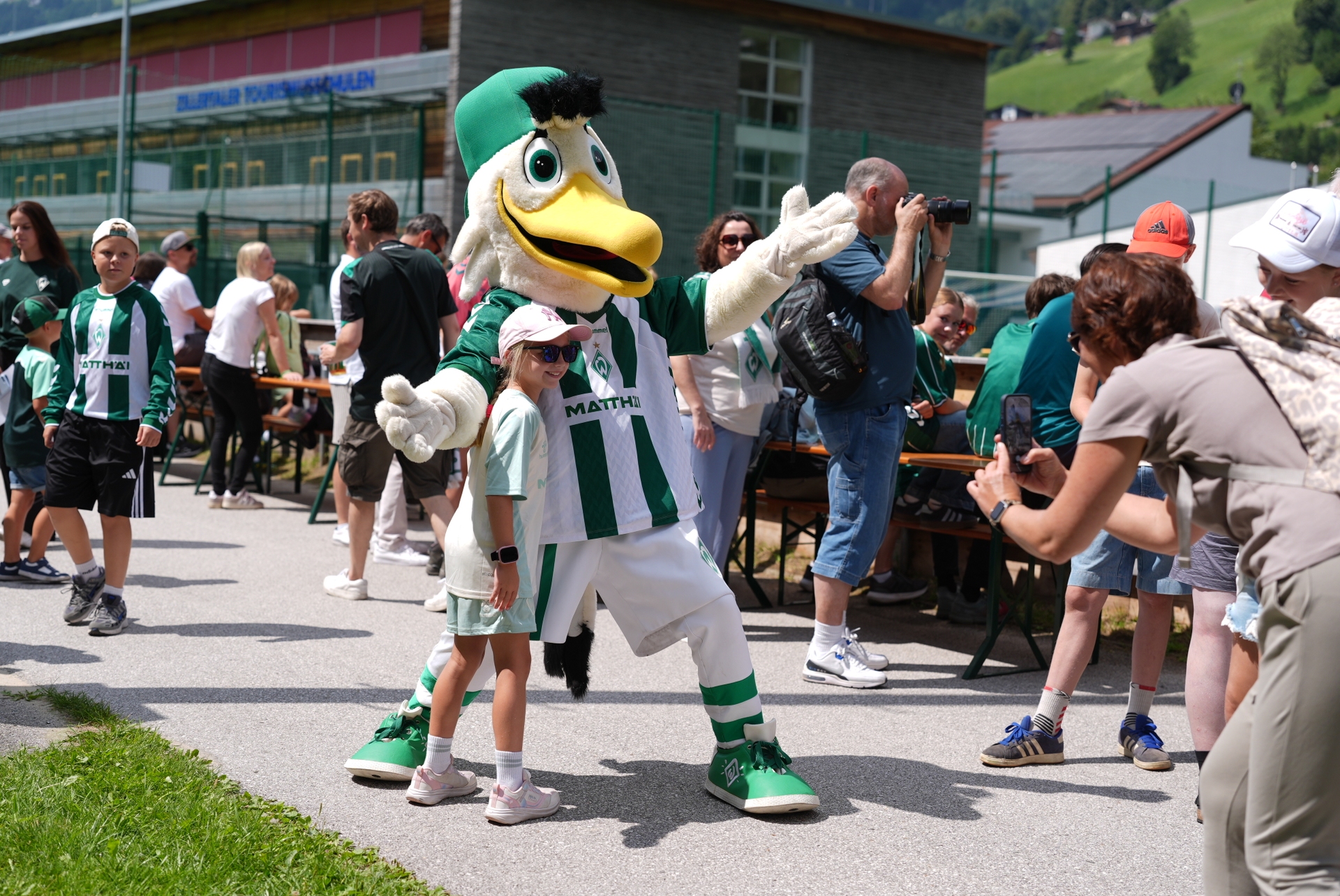 Möwe Toni macht im Trainingslager ein Foto mit einem Fan.