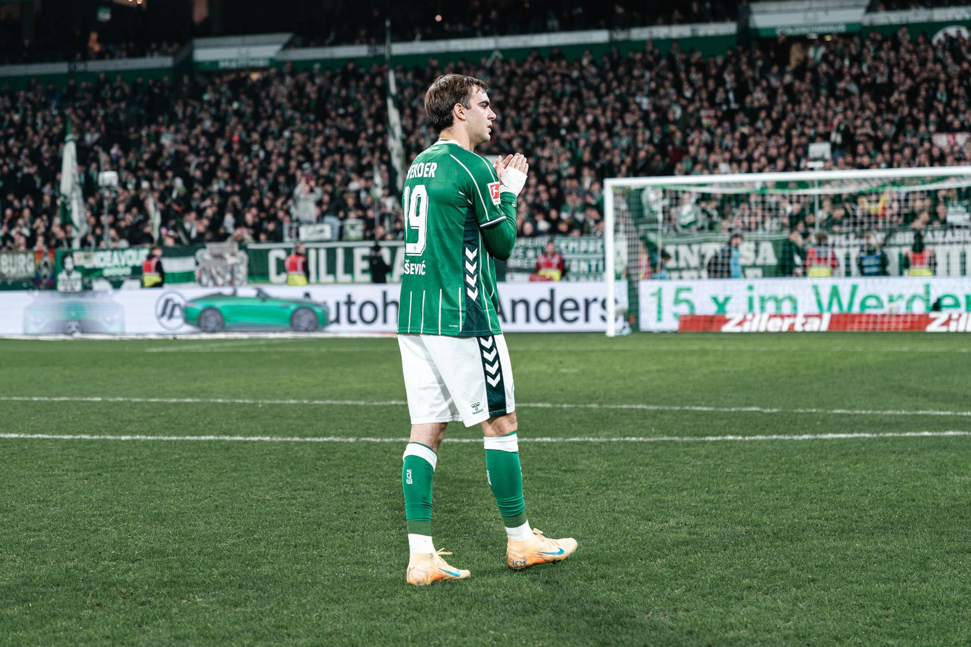 Jovan Milosevic klatscht. Im Hintergrund ist die Ostkurve zu sehen.