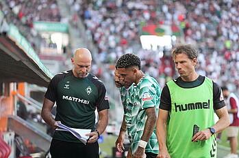 Justin Njinmah schaut vor seiner Einwechselung auf einen Zettel, den ihn Christian Vander zeigt.