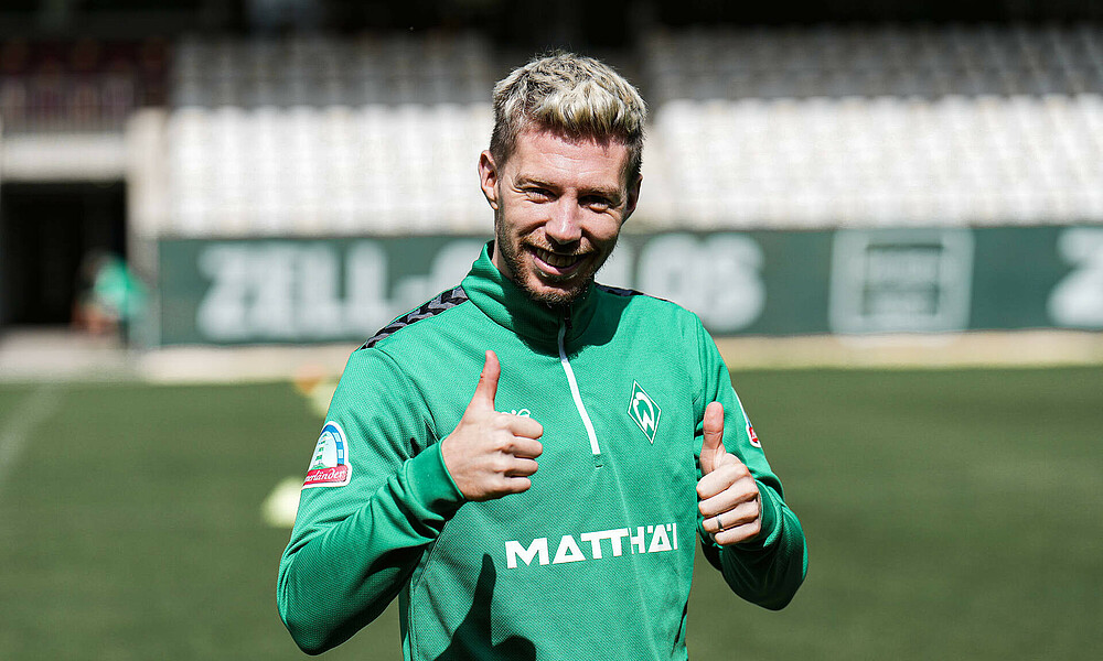 null Mitchell Weiser streckt beide Daumen nach oben und lacht.