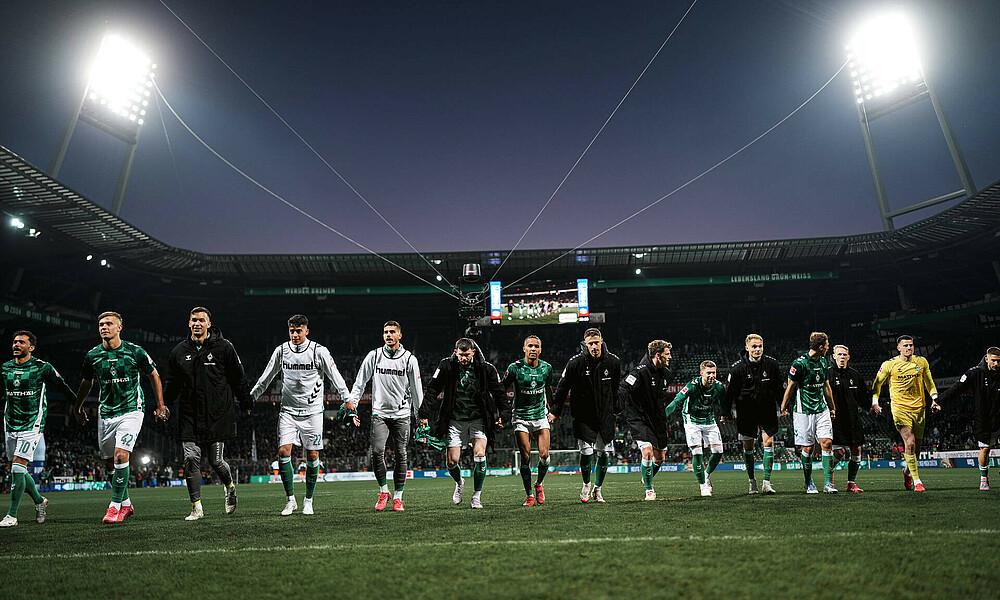 null Werder-Spieler jubeln gemeinsam vor der Ostkurve