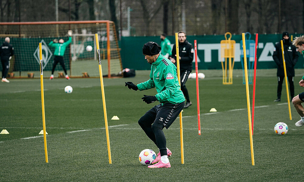Justin Njinmah dribbelt während des Trainings zwischen gelben Stangen durch.