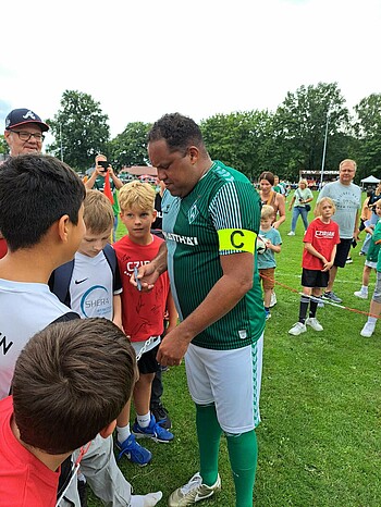 Ailton unterschreibt Trikots. 