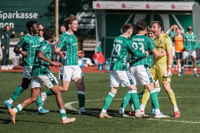 Die Spieler der U23 schreien sich vor Freude an und laufen aufeinander zu.