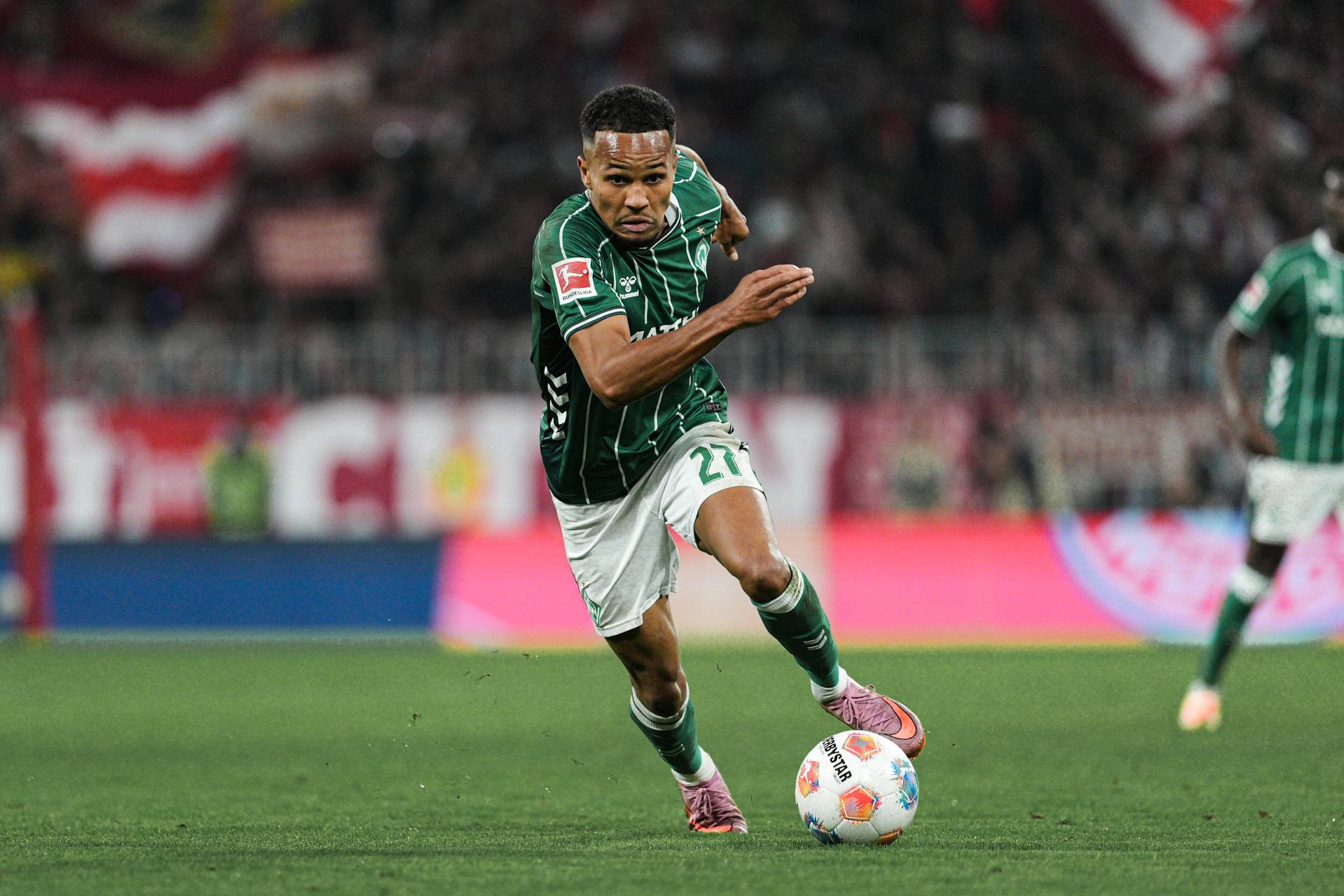 Felix Agu mit Ball am Fuß im Werder-Trikot beim Hinspiel in München.