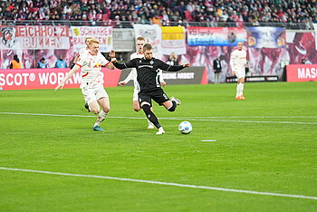 null Romano Schmid mit einem grünen Mikrofon in der Hand.
