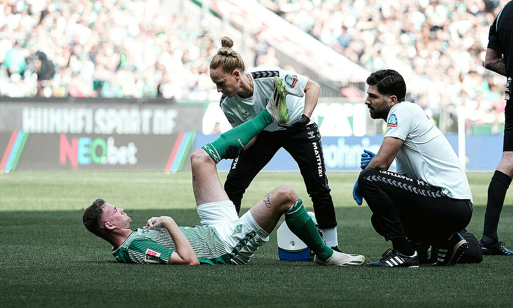 Marvin Ducksch liegt auf dem Boden während des Spiels und wird behandelt.