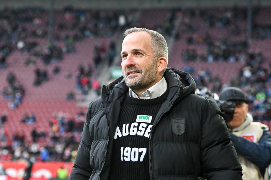 Manuel Baum in einer Augsburg-Jacke und einem Pulli des Vereins.