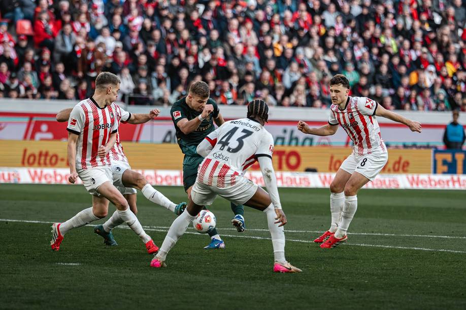 Keke Topp dreht zum Abschluss auf, er ist von mehreren Freiburgern umzingelt.