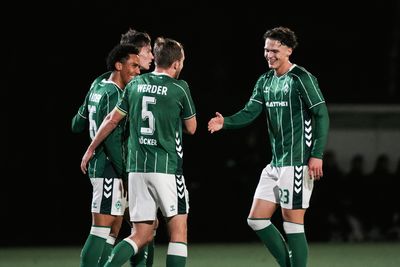 Drei Spieler U23 umarmen sich. Ein vierter Spieler streckt die Hand zum Abklatschen aus.