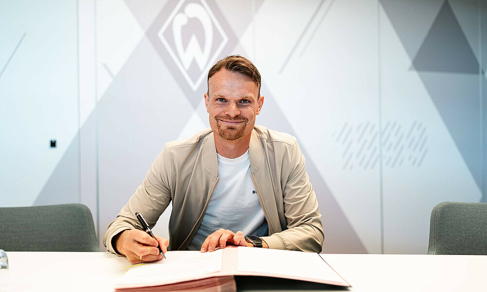 Christian Groß unterschreibt seinen Vertrag. 