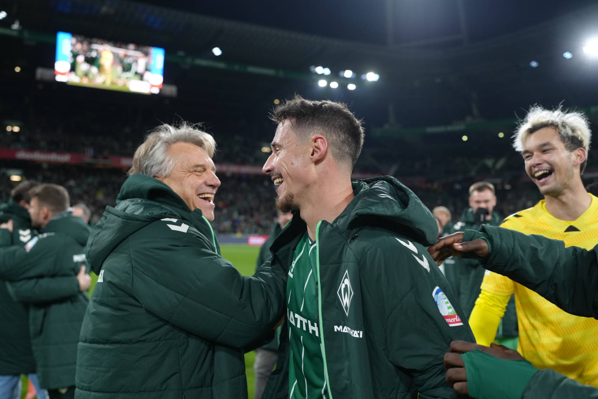 Marco Friedl lacht mit Horst Steffen auf dem Platz.