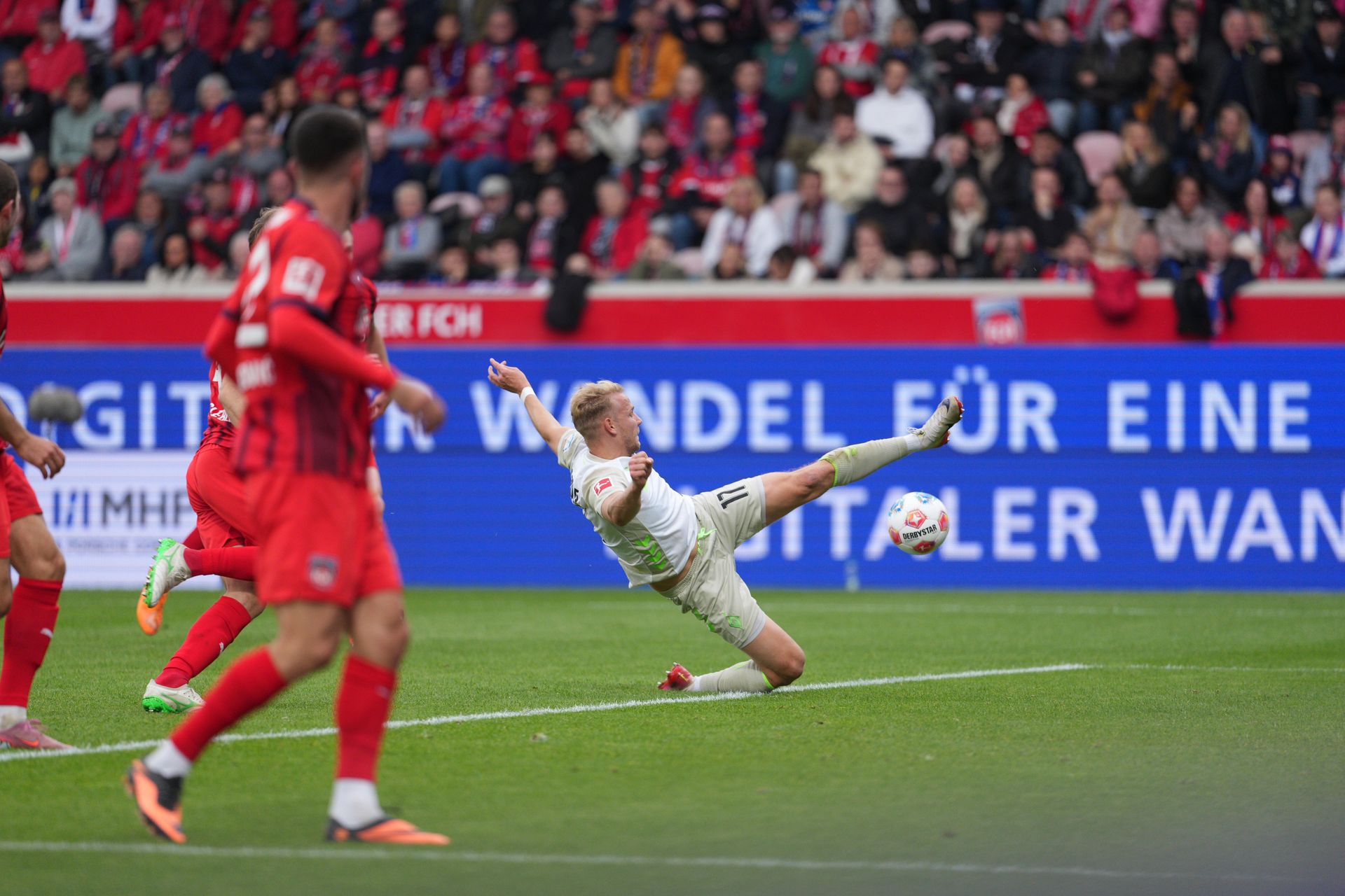 Marco Grüll mit ausgestrecktem Bein in Richtung Spielgerät.