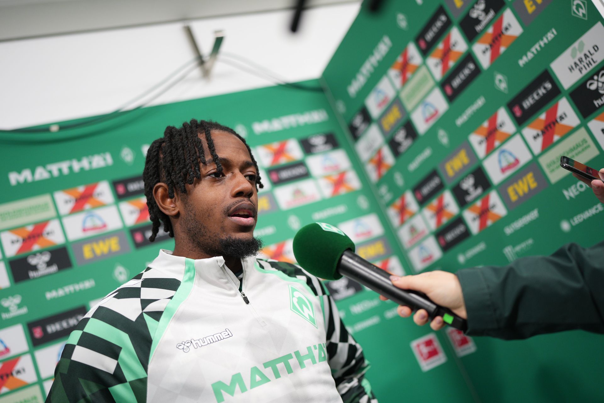 Samuel Mbangula am Mikrofon bei WERDER.TV in der Mixed Zone