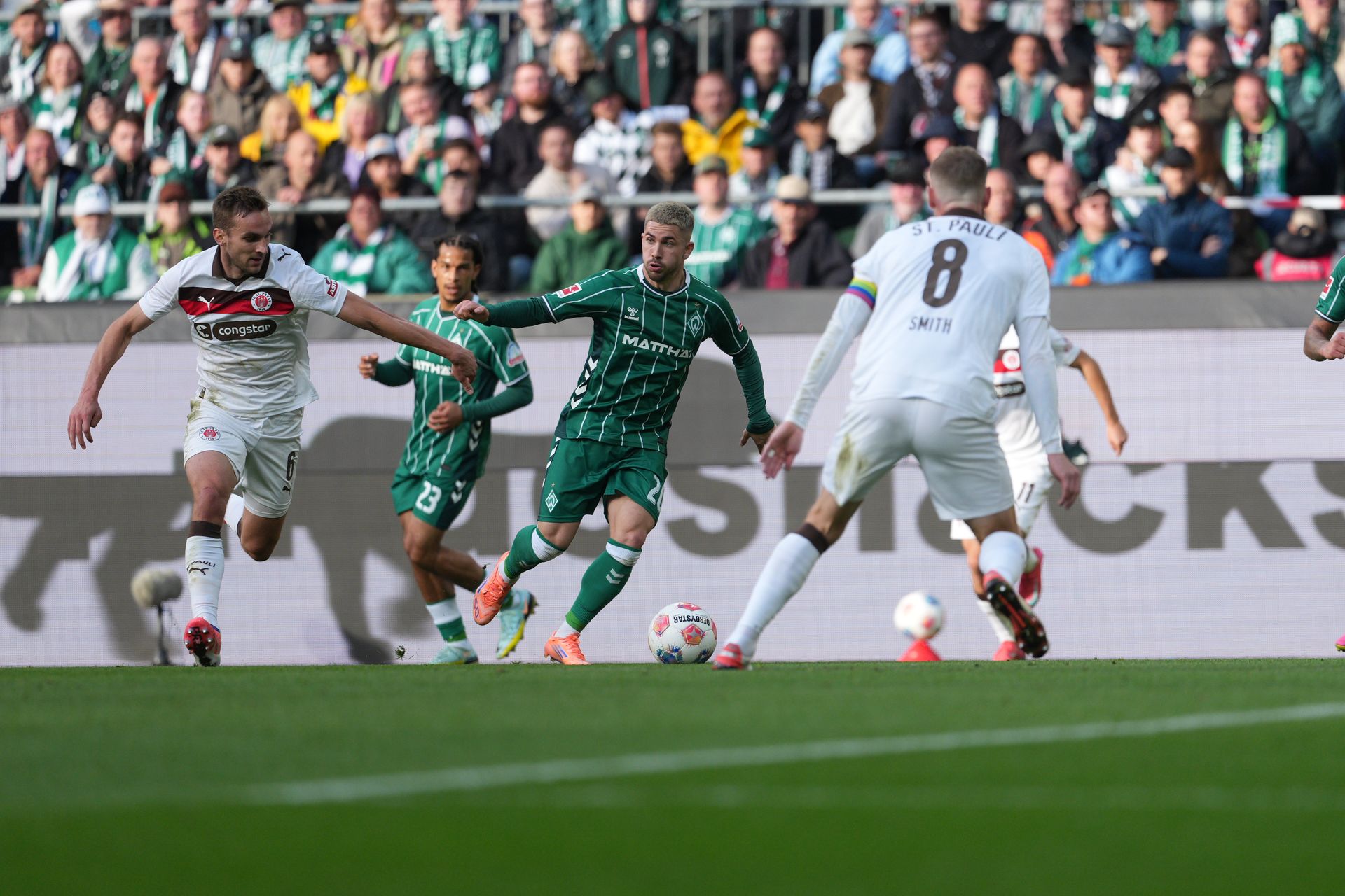 Romano Schmid dribbelt verfolgt von zwei St. Pauli-Spielern Richtung Sechzehner.