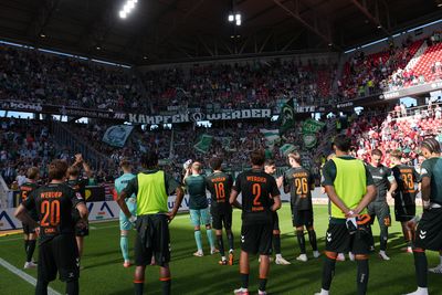 Werder-Spieler vor dem vollen Gästeblock mit Werder-Fans in Freiburg