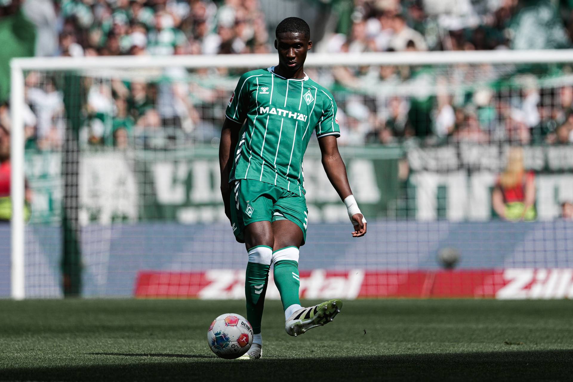 Karim Coulibaly spielt einen Pass und trägt dabei das Werder-Trikot.