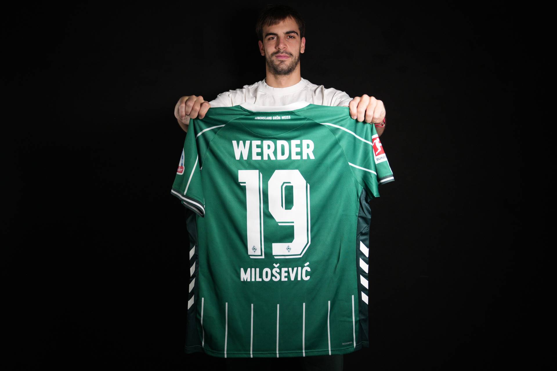 Jovan Milošević mit seinem Trikot in der Hand - er trägt die Rückennummer 19.