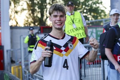 Mick Schmetgens celebrates, wearing a Germany shirt.