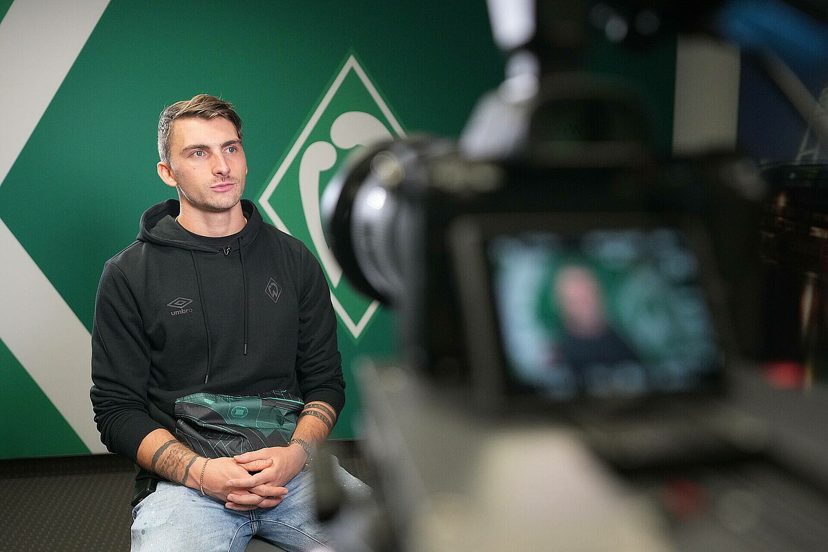 Maximilian Philipp sitzt vor der Kamera. 