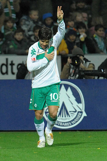 Diego im Trikot 2009 zeigt auf die Werder-Raute und hebt die linke Hand in die Luft
