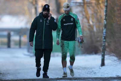 Mio Backhaus läuft mit einem Betreuer nach dem Training mit einem verbundenen Kopf vom Trainingsplatz.