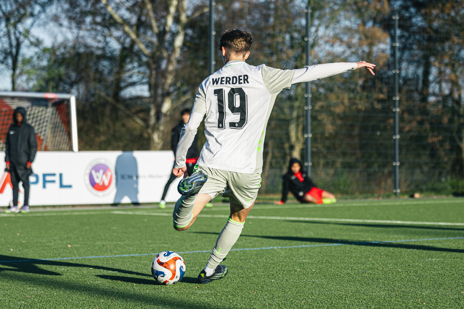 Der Spieler der U16 befindet sich in seinem weißen Werder-Trikot kurz vor dem Abschuss.
