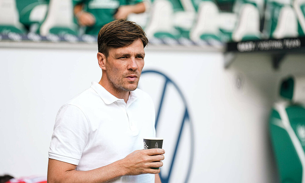 Clemens Fritz mit einem Kaffeebecher in der Hand. 