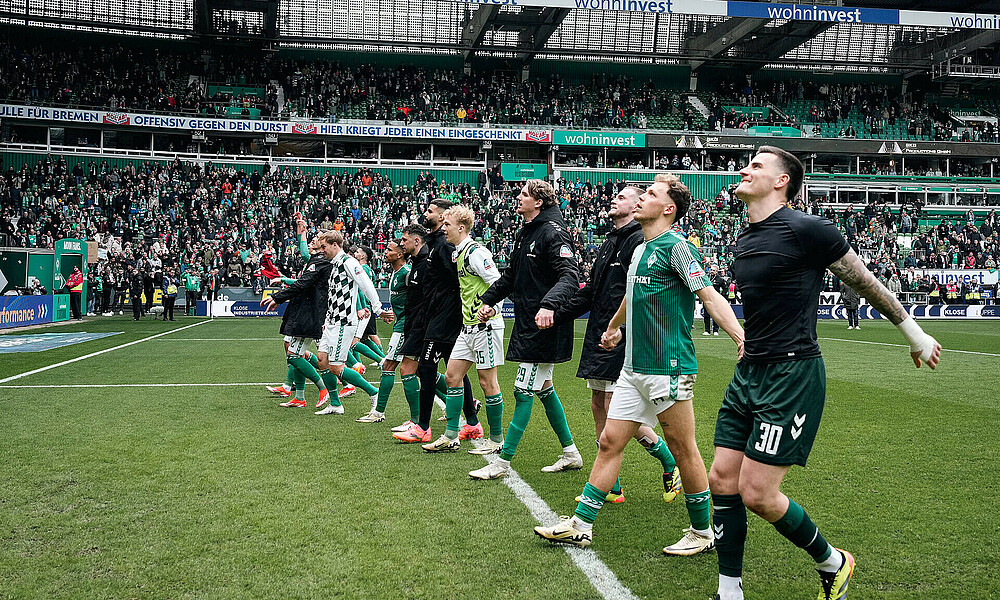 Die Mannschaft jubelt vor der Ostkurve.  