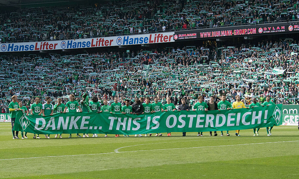 null Die Werder-Spieler stehen auf einem Banner auf dem