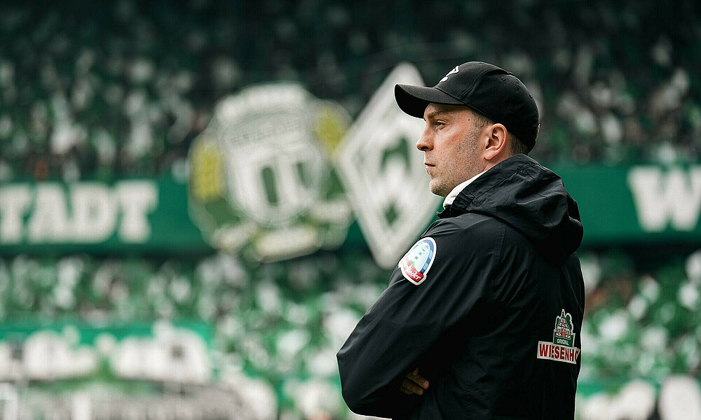 null Ole Werner am Seitenrand, im Hintergrund die Choreo der Fans.