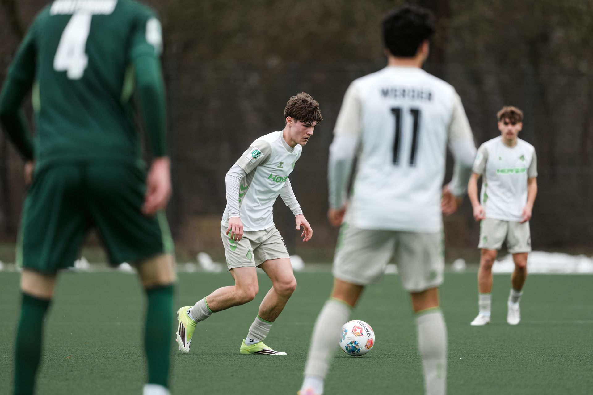 Ein Spieler der U17 läuft mit dem Ball am Fuß über den Kunstrasen.