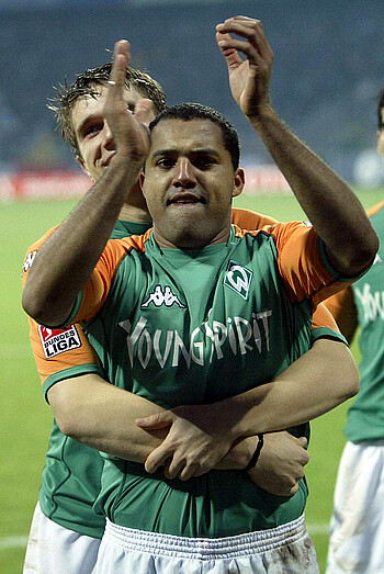 null Ailton wir von hinten in den Arm genommen. Er klatscht.