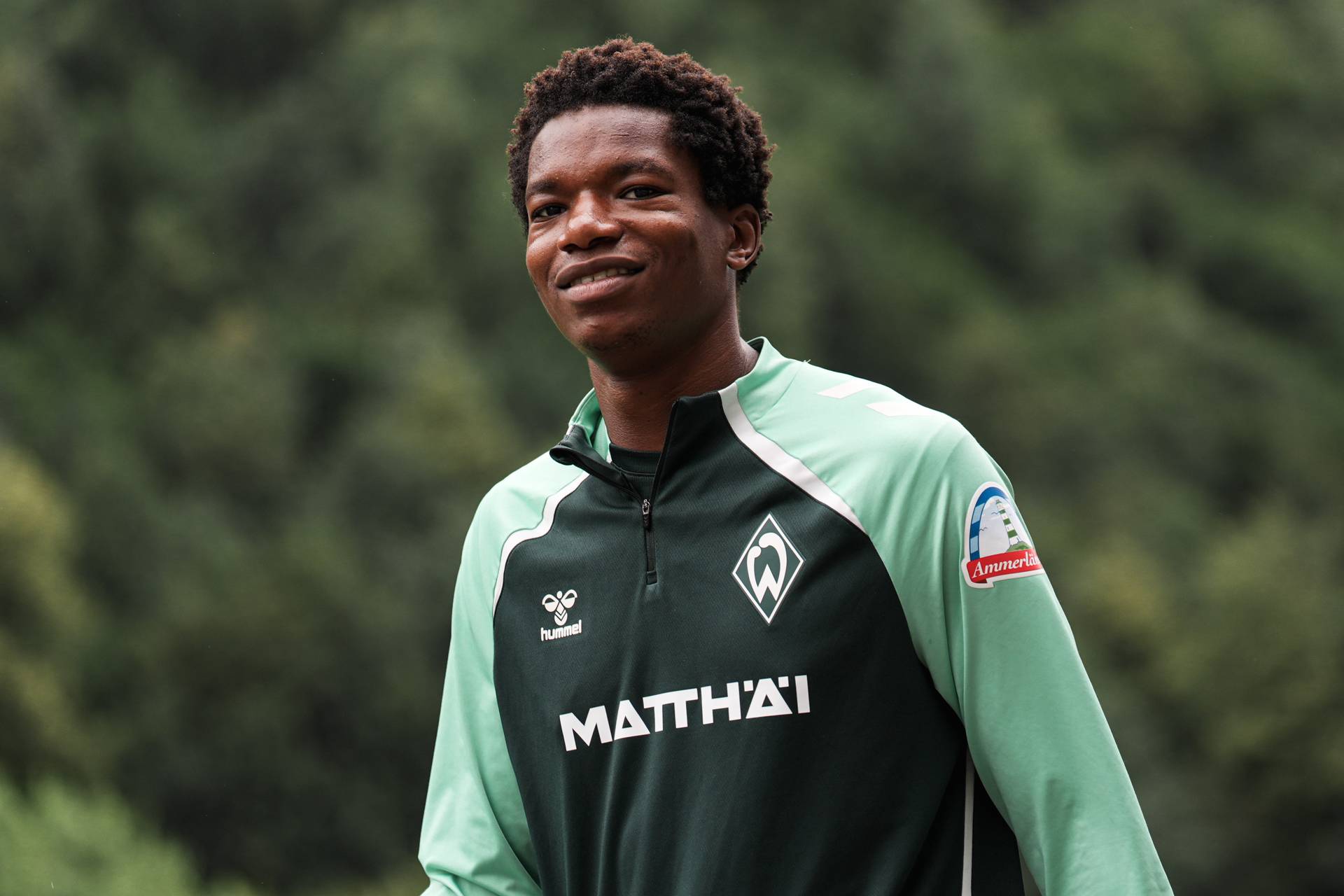 Skelly Alvero smiles wearing a Werder training shirt