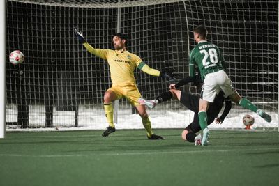 Ole Springer versucht einen Ball zu parieren, der auf ihn zufliegt, während zwei Spieler vor ihm stehen.