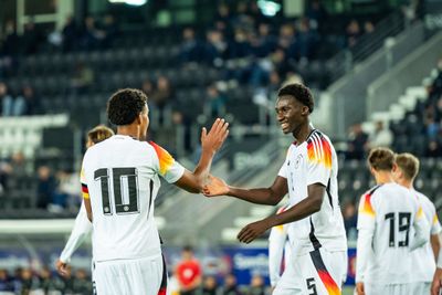 Karim Coulibaly klatscht mit einem Mitspieler ab.