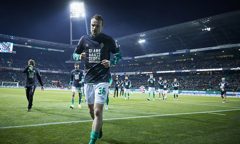Christian Groß mit einem Aufwärmshirt mit der Aufschrift 