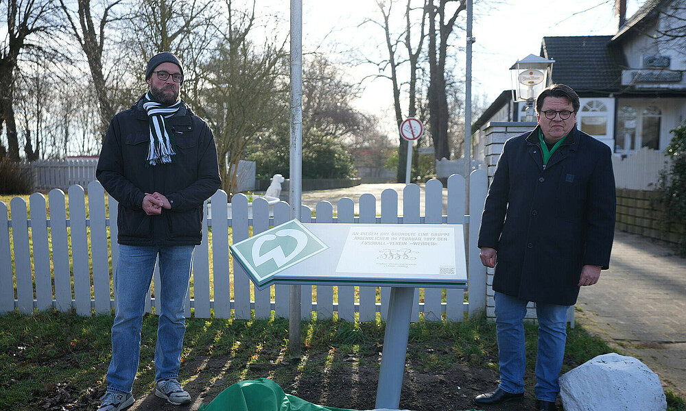 Werder-Präsident Dr. Hubertus Hess-Grunewald steht neben der neu enthüllten Infotfafel