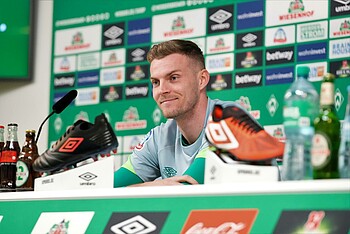 Marvin Ducksch während der Mixed Zone lächelnd auf dem Podium im PK-Raum.