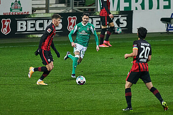 null Leonardo Bittencourt am Ball, zwei Frankfurter laufen ihn an.