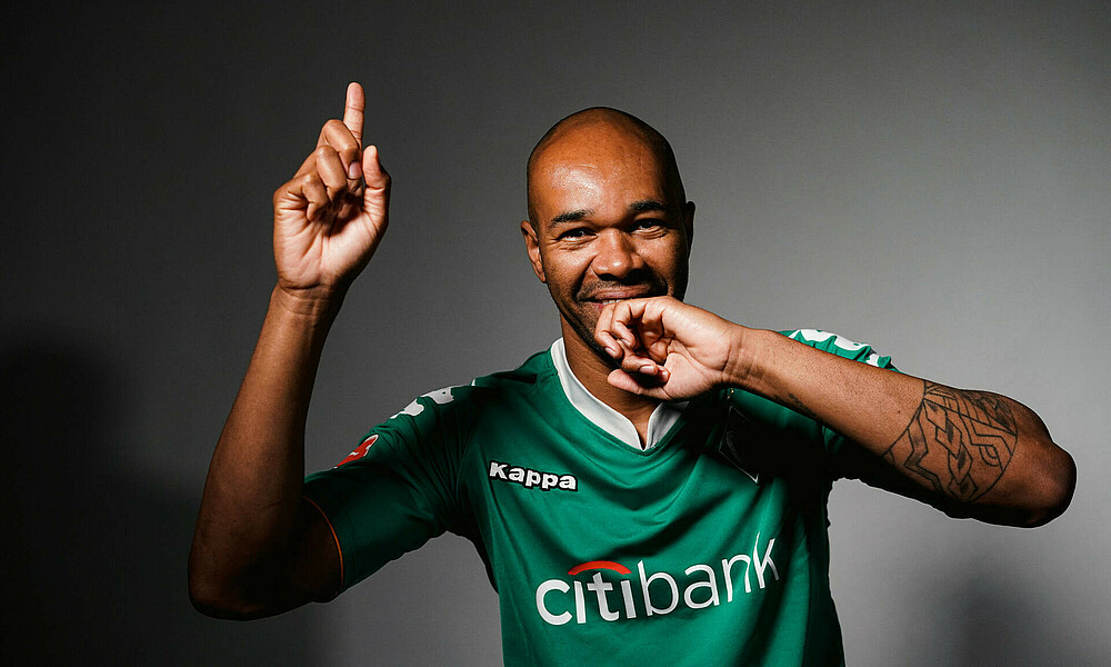 Naldo jubelt im grünen Werder-Trikot bei einem Foto-Shooting.