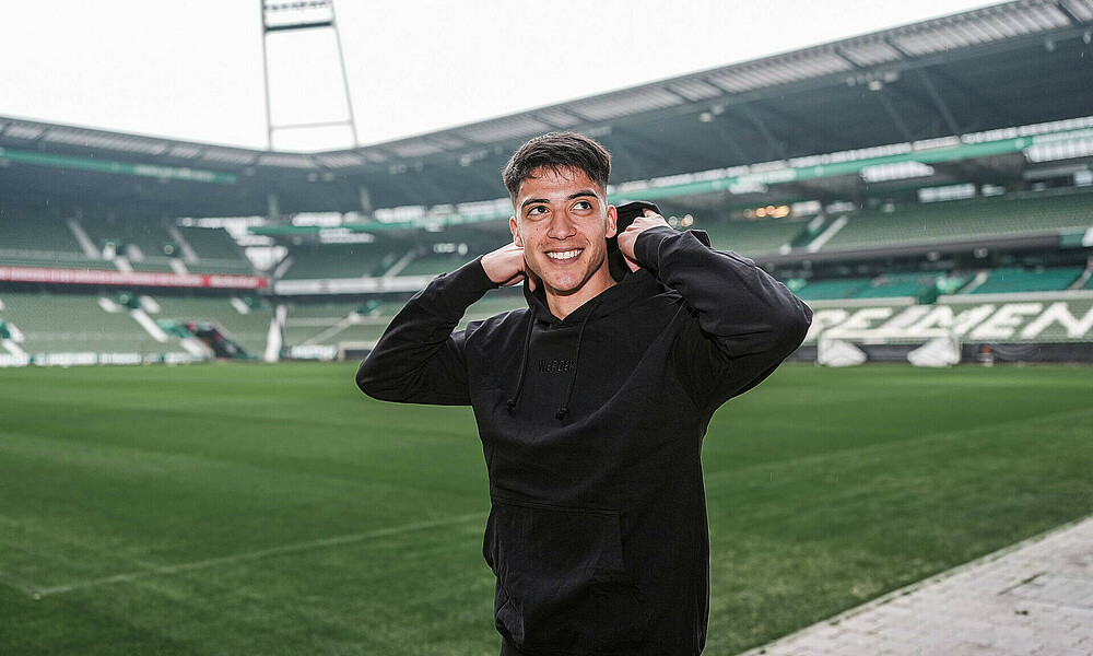 Julian Malatini im Werder Kapuzenpullover in Schwarz im Weserstadion