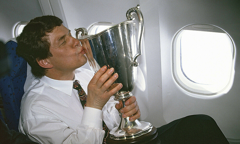 Otto Rehhagel küsst den Europapokal der Pokalsieger im Flugzeug.