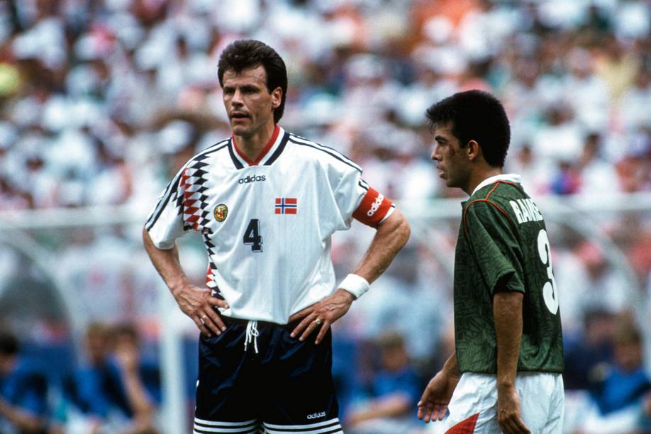 Ein Spieler im weißen Trikot stemmt die Hände in die Hüfte. Daneben steht ein Spieler im grünen Trikot.
