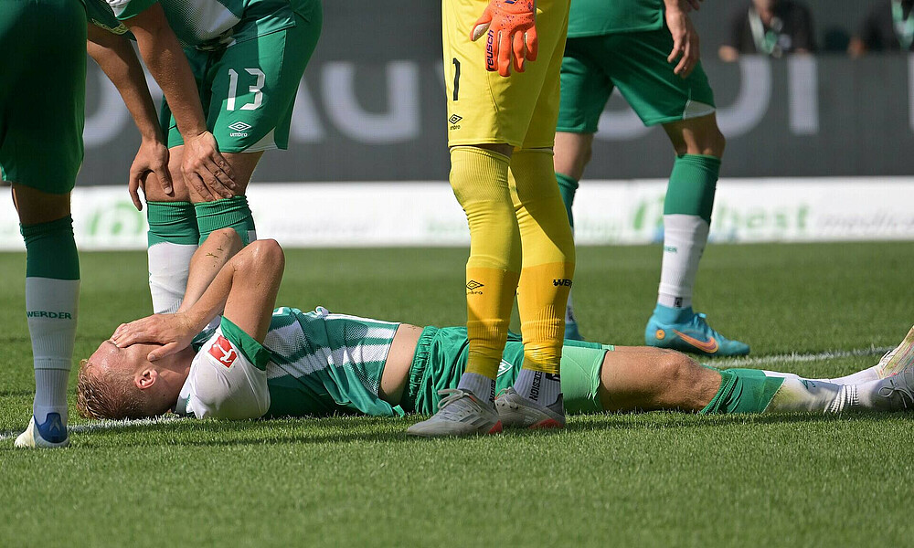 Amos Pieper liegt am Boden und hält die Hände vor sein Gesicht