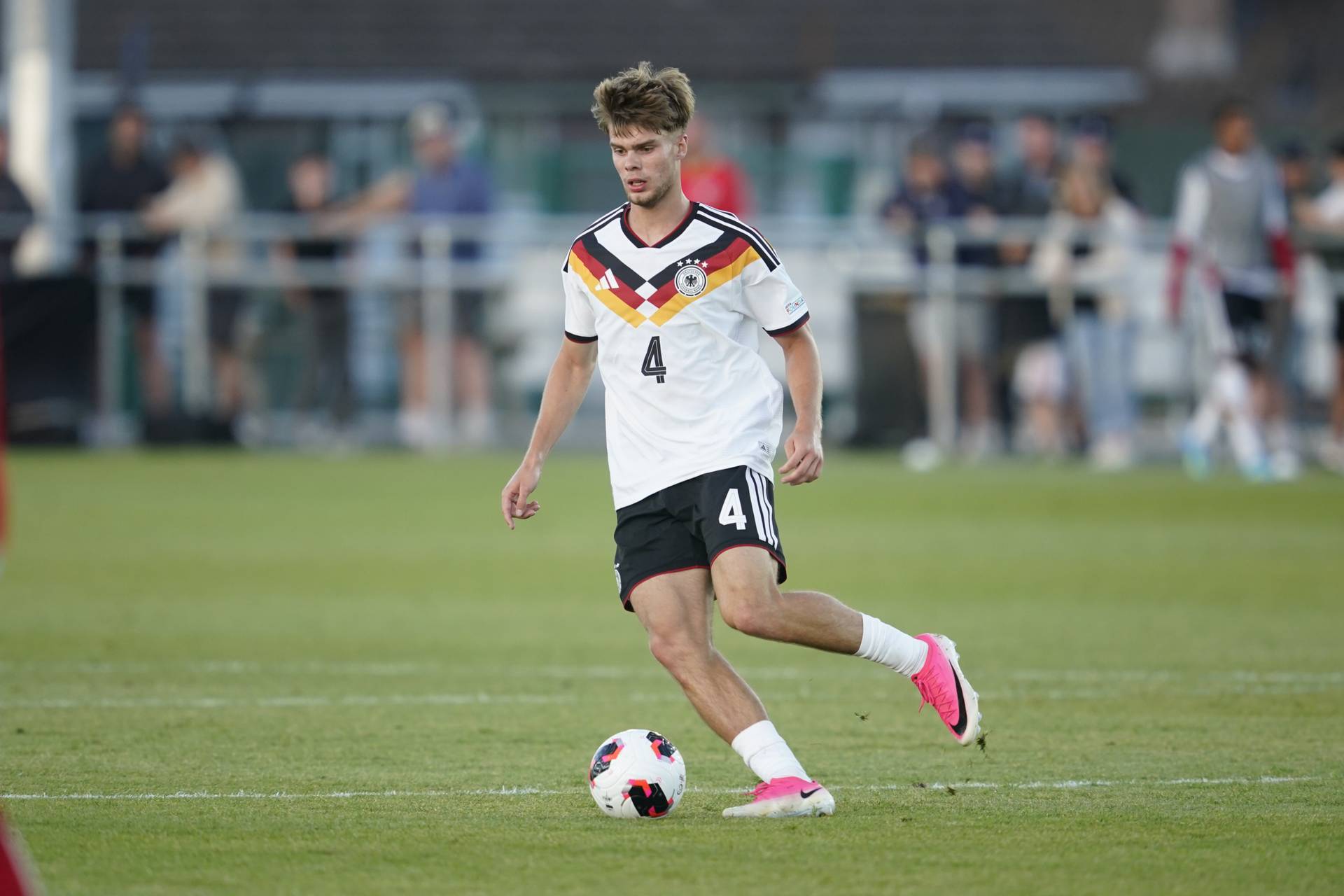 Mick Schmetgens holt im DFB-Trikot mit dem Ball am Fuß zum Passen aus.